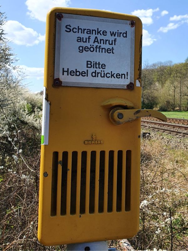 Hinweisschild mit dem Text: Schranke wird auf Anruf geöffnet